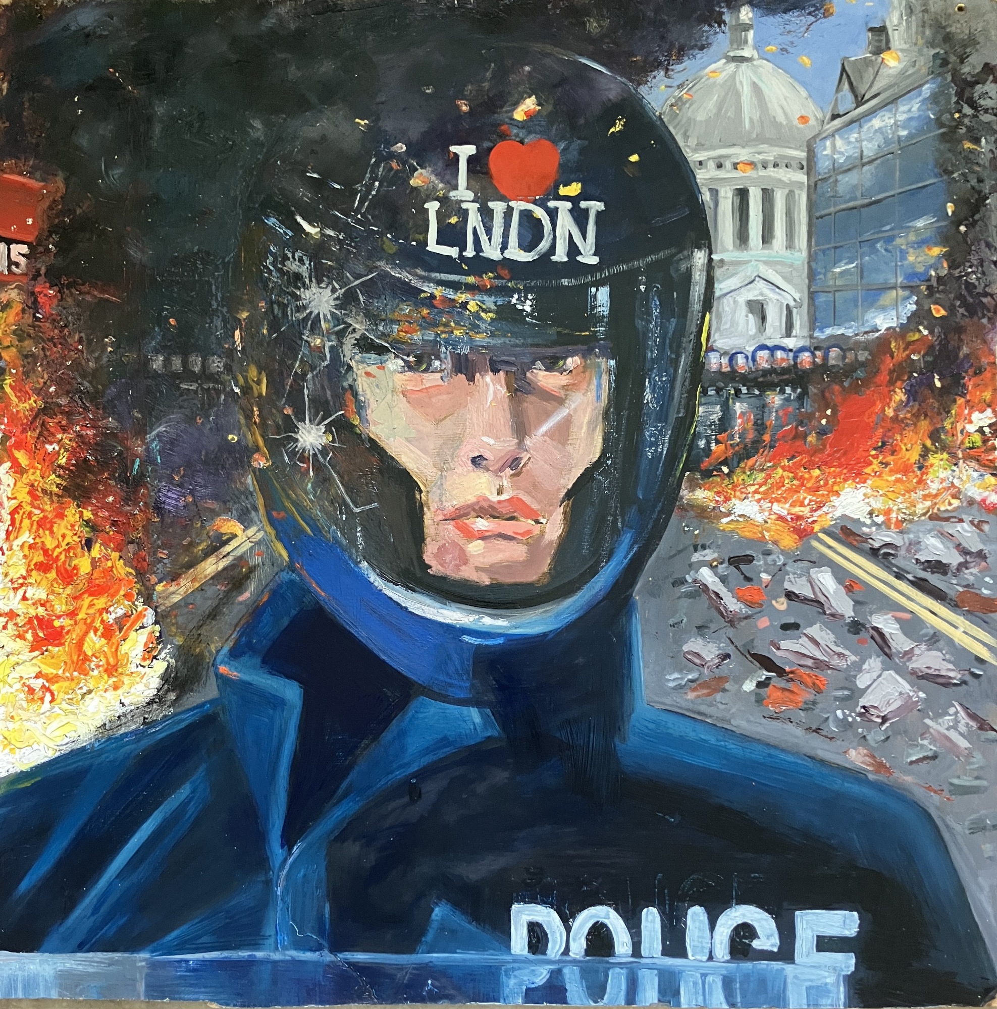 A policeman stands in front of a burning street. His colleagues in a line behind...