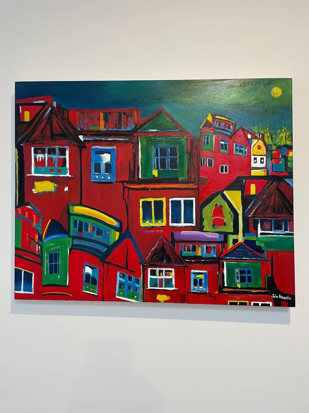 This vivid painting presents a lively urban landscape where brightly colored hou...