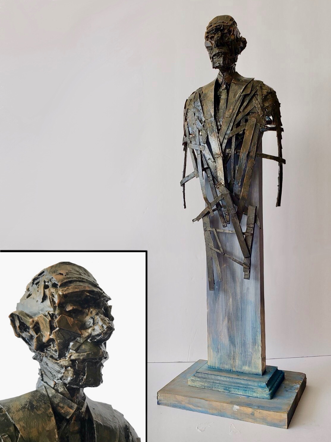 A sculpture of a standing figure finished in a bronze-like texture.